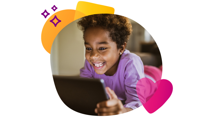 young brown skin girl smiling while looking at a tablet