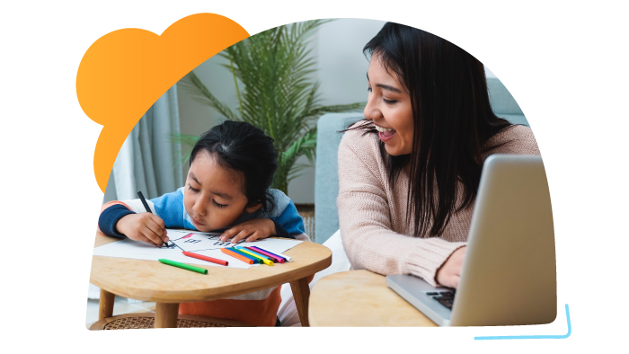 woman using laptop with small child coloring